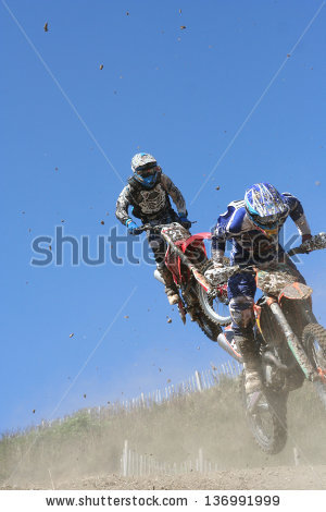 Two Motocross motorcycles jump